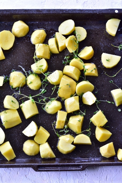 Potatoes and thyme on a baking tray