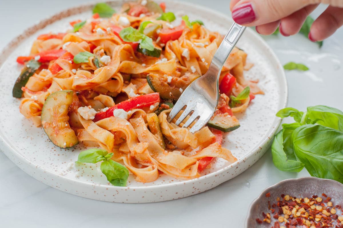 vegetable pasta is being stick on a fork