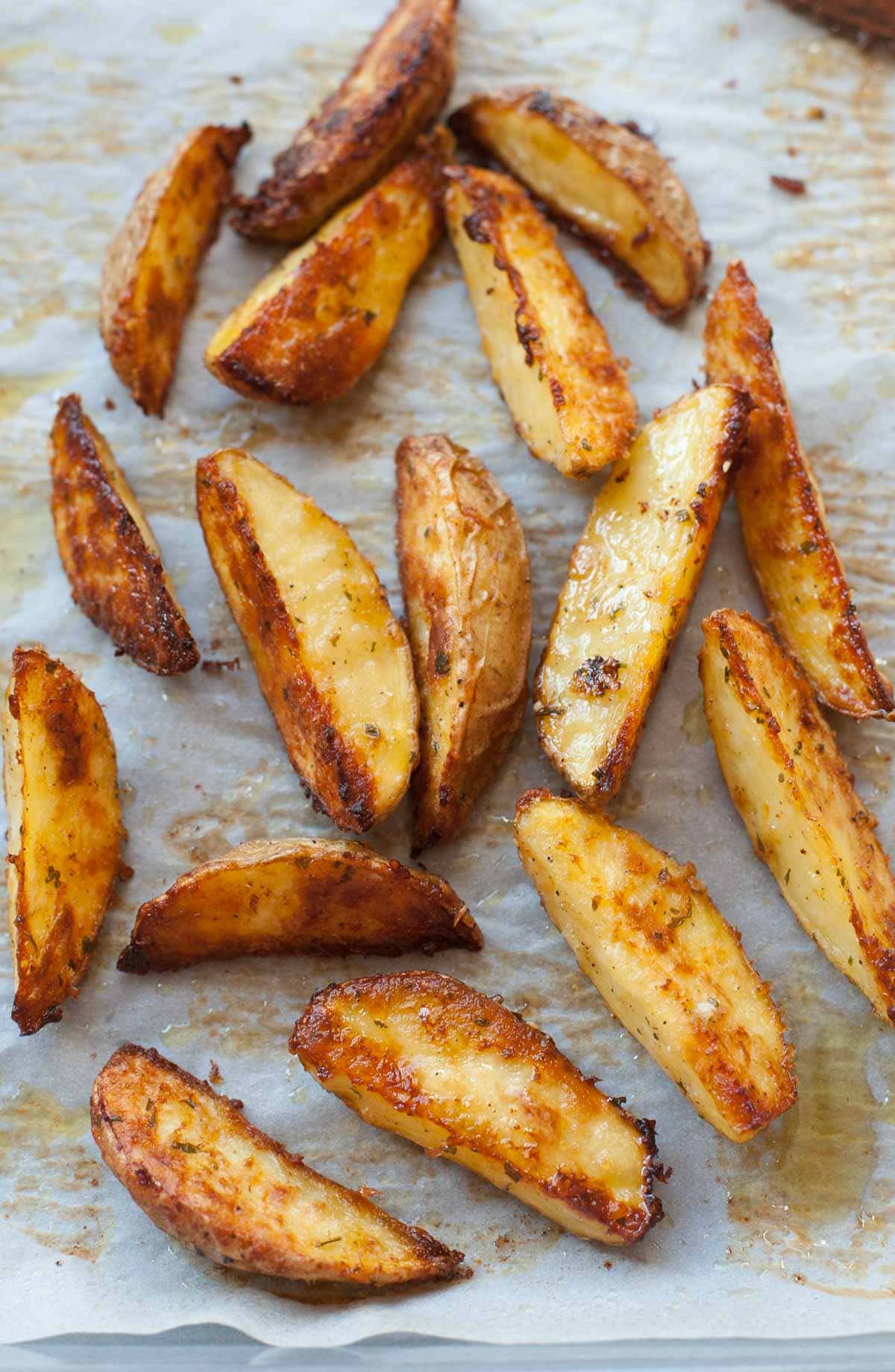 Roasted potato wedges on a baking sheet.