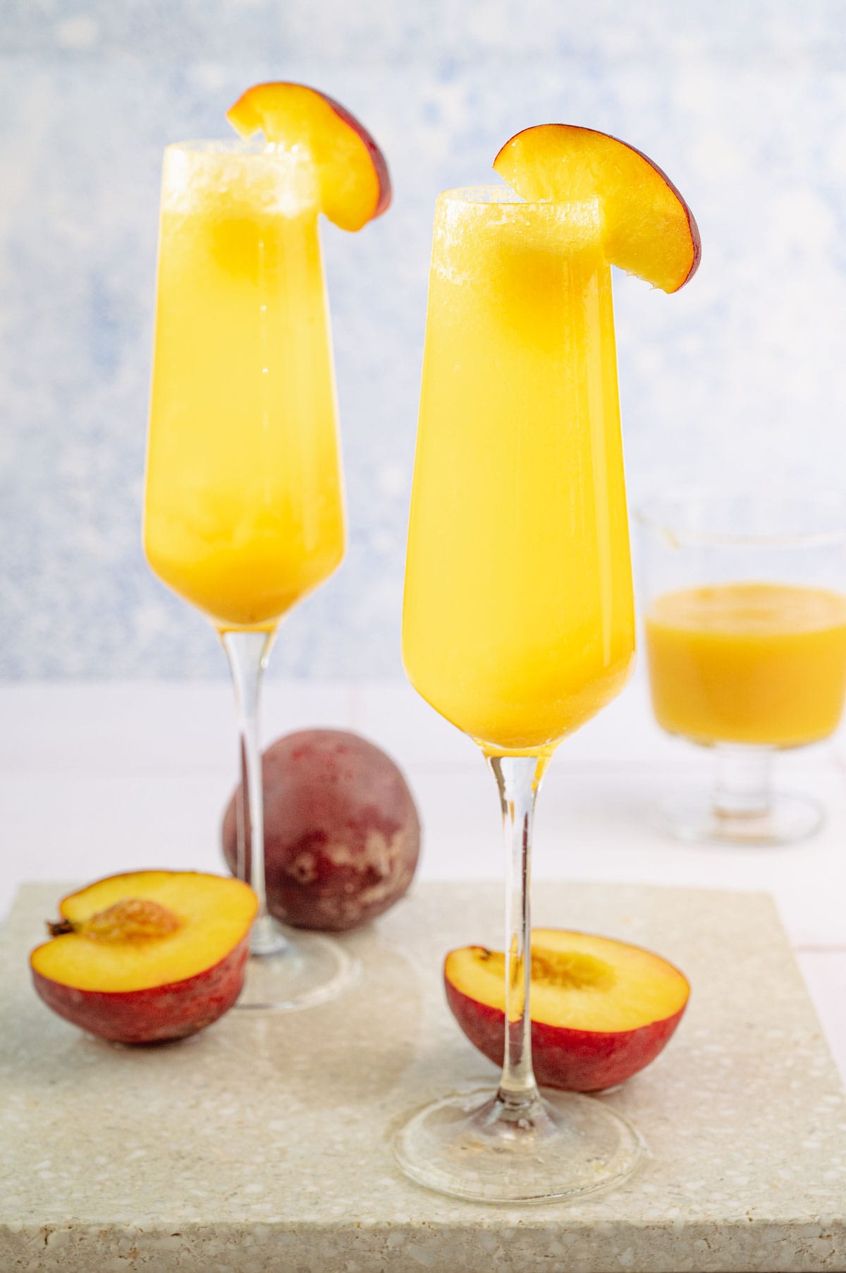 Two champagne glasses with peach bellini.