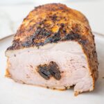 Polish pork loin roast stuffed with prunes cut in half on a plate.