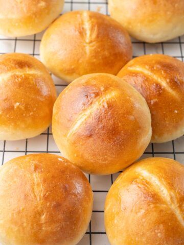 Brötchen bread rolls on a black cooling rack.