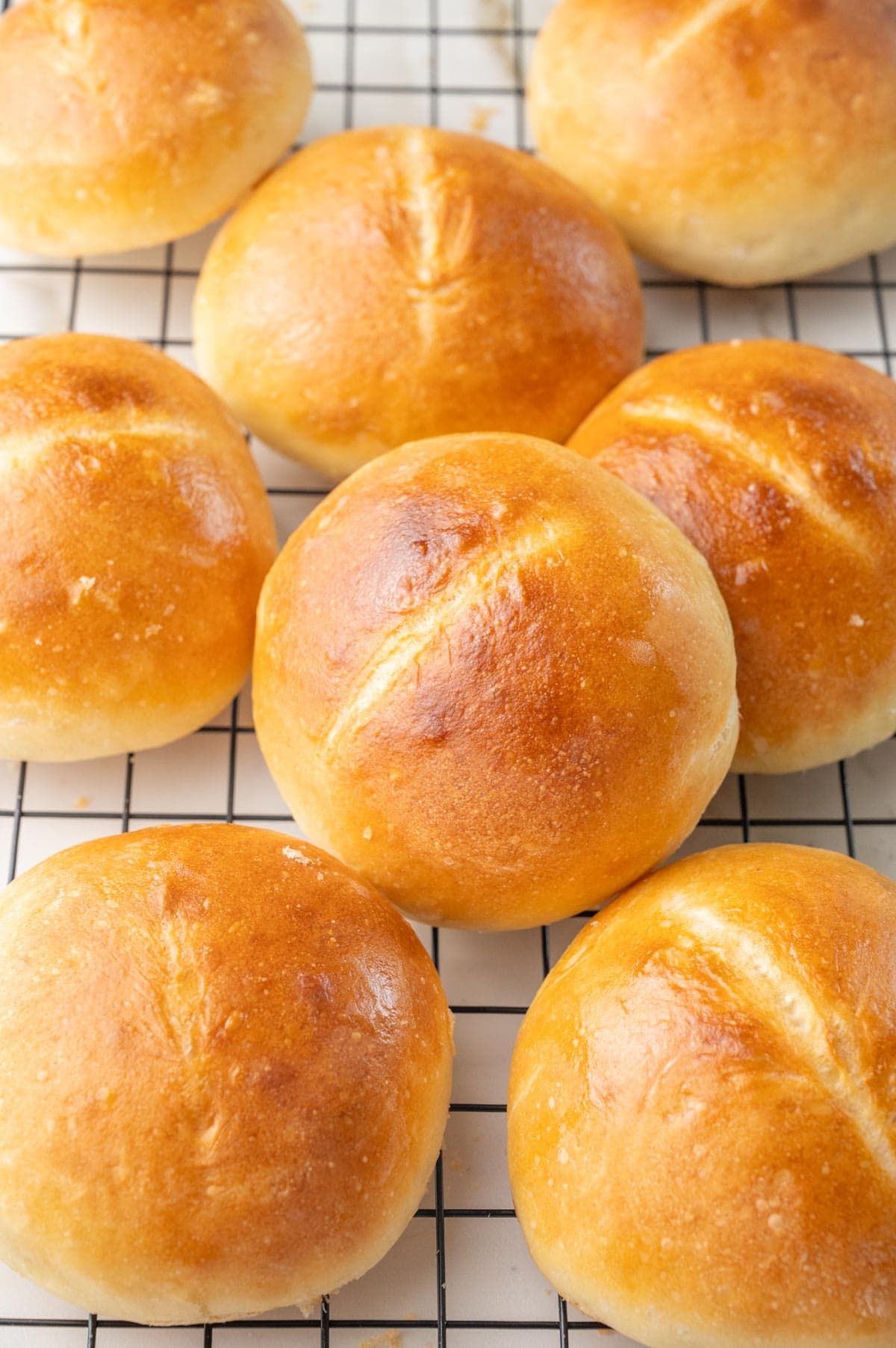 Brötchen bread rolls on a black cooling rack.