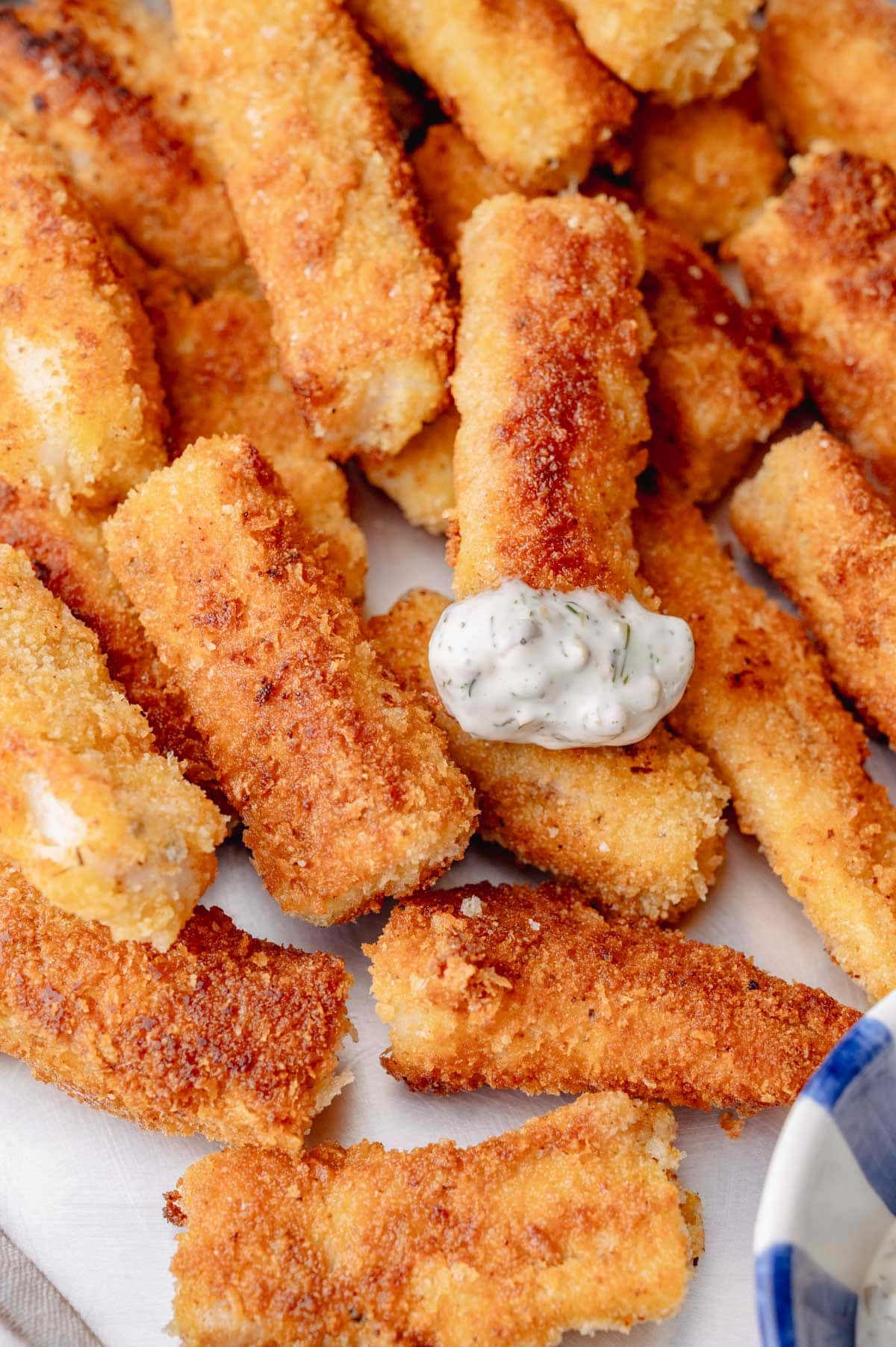 Close-up of crunchy homemade fish sticks topped with creamy tartar sauce.








Ask ChatGPT
