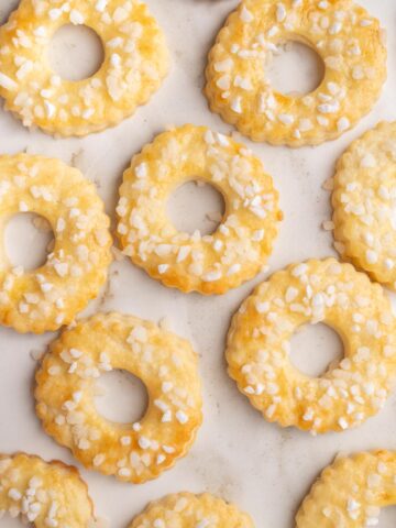 Saure-Sahne-Kringel cookies on a marble counter.